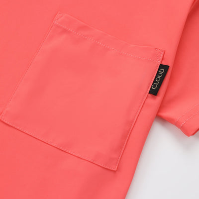 Close-up of a coral-colored shirt with a brand label on a white background